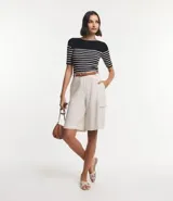 Blusa de punto con textura acanalada, diseño de rayas horizontales en azul marino y blanco, escote barco y manga corta.