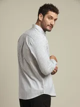 Camisa de manga larga con corte slim fit, confeccionada en algodón con diseño de rayas verticales en tonos blanco y azul. Presenta cuello con botones y logo bordado en el pecho.