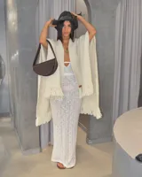 Vestido largo de tejido de punto calado color crema, con escote halter y espalda descubierta.