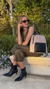 Mochila urbana de diseño combinado, confeccionada en tela resistente con bolsillo frontal y detalles en cuero sintético. Cuenta con compartimento principal con cierre y correas ajustables.