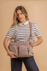 Bandolera de tafeta impermeable color beige, con dos bolsillos frontales con cierre y correa regulable. Diseño práctico y liviano ideal para uso diario.