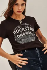 Remera de algodón color negro, con cuello redondo y mangas cortas. Presenta un estampado frontal circular con la frase 'ROCKSTAR DREAMS' y detalles de estrellas con apliques brillantes.