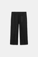 Pantalón marrón de tiro alto con bolsillos delanteros y traseros. El bajo está acabado con vuelta. Cierre frontal con cremallera y ganchos metálicos.