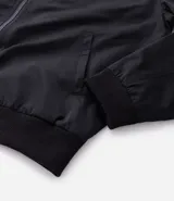 Campera bomber color beige, con cuello alto, cierre frontal con cremallera, bolsillos laterales y puños y cintura elastizados.