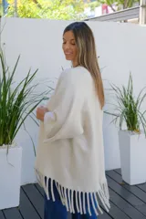 Saco abierto de corte recto y holgado, color visón, con mangas tres cuartos y detalle de flecos largos en el ruedo.