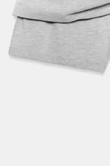 Falda corta gris melange de tiro medio con cintura elástica, confeccionada en hilatura con mezcla de algodón. Cuenta con forro interior tipo shorts del mismo tejido.