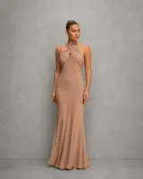 Vestido largo color tostado con escote halter cruzado y diseño drapeado que se ajusta a la silueta, de caída fluida y elegante.