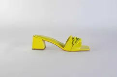Sandalias tipo sueco color amarillo, con taco ancho y aplique de cadena en el empeine.