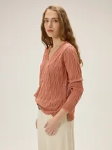 Buzo de tejido en lurex con escote en V, manga larga y silueta relajada, con un brillo sutil y textura tramada.