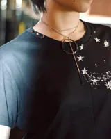 Remera negra de manga corta y cuello redondo con detalles en tachas, efecto lavado desgastado y estampado frontal.