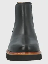 Botin tipo Chelsea de cuero negro con paneles laterales elásticos y detalle de textura en el talón. Cuenta con una suela de plataforma dentada en color negro con una franja intermedia en tono madera.