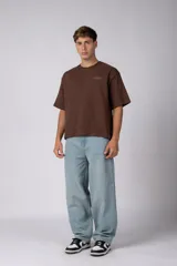Remera boxy de algodón color marrón, de mangas corta y calce holgado, con estampa sutil con la leyenda 'COFFEE' en el pecho.