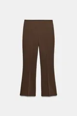 Pantalón de tiro medio con cintura elástica y corte mini flare, acabado en evasé. Cuenta con cierre lateral con cremallera oculta en la costura.