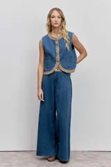 Pantalón de jean azul de corte ancho y tiro alto, con costuras verticales frontales que estilizan la silueta y diseño de pierna recta.