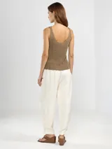 Pantalón estilo cargo de color marrón, confeccionado en una mezcla de lino y lyocell. Presenta cintura elástica con cordón ajustable, bolsillos laterales tipo parche y detalle de botones en los tobillos para un ajuste opcional.