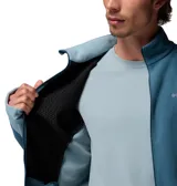 Campera polar con cierre frontal completo, cuello alto y mangas largas con orificios para pulgares. Presenta un diseño en dos tonos de azul con paneles laterales en un tono más claro y logo de la marca bordado en el pecho.