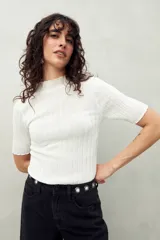 Top negro de manga corta tejido con textura acanalada, cuello alto y terminaciones onduladas.