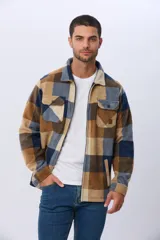 Campera leñadora de tejido polar con estampado a cuadros en tonos marrones, beige y azules. Presenta cierre frontal, cuello camisero, bolsillos superiores con solapa y bolsillos laterales.