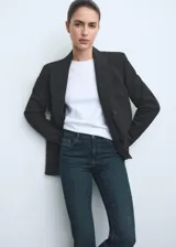 Jeans de tiro medio con corte flare y bajo deshilachado. Presentan diseño de cinco bolsillos, cierre frontal con cremallera y botón, y trabillas para cinturón.