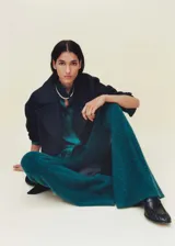 Pantalon de tejido de punto con diseño acampanado y tiro medio. Cuenta con cintura elástica y diseño largo.