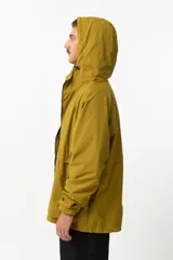 Campera de nylon color mostaza, estilo 'gorpcore', con forro de jersey de algodón y corte confortable. Presenta cierre frontal, capucha y bolsillos laterales. Estampado en el pecho con el logo de la marca y la frase "Release the hounds".