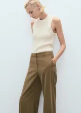 Pantalón sastrero de tiro medio, color marrón, con diseño recto, bolsillos laterales y trabillas para cinturón. Cuenta con cierre oculto de botón, gancho y cremallera.