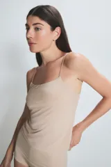 Musculosa de breteles finos, color beige, con escote recto y calce ajustado al cuerpo.