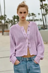 Chaqueta de punto grueso color lila con cuello redondo, manga larga, acabados en rib y cierre frontal con botones nacarados.