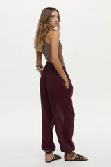 Pantalón babucha bordó con elástico en la cintura trasera y bolsillos laterales, de corte amplio y fluido.