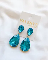 Aros colgantes con forma de lágrima, con engarce dorado y cristales facetados color turquesa.