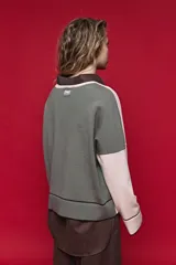 Sweater tejido celeste de calce relajado con cuello redondo, hombros caídos y puños y ruedo acanalados con detalles en tono tostado.
