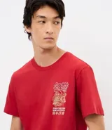 Remera de algodón color rojo, con cuello redondo y manga corta. Presenta un estampado frontal pequeño en el lado izquierdo del pecho con diseño gráfico y lettering Fighting and Devotion.