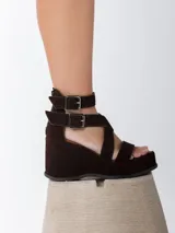 Sandalias de cuero marrón con acabado en gamuza, taco de 8 cm y plataforma forrada. Diseño con doble tira ajustable con hebillas metálicas y cierre trasero.