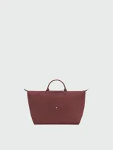 Bolso de viaje grande Longchamp modelo Le Pliage, color negro, confeccionado en nylon con detalles de cuero en las asas y solapa frontal con cierre de botón a presión.