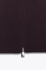 Top de punto canalé en color bordó, sin mangas y con cuello alto. Presenta un cierre frontal completo con cremallera metálica.