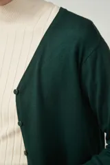 Cárdigan color beige con escote en V y cierre frontal con botones.