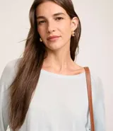 Suéter de punto color celeste, con cuello redondo y mangas largas.