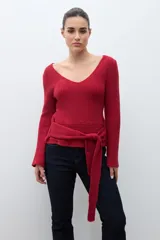 Sweater de punto acanalado color rojo, con escote en V, mangas largas acampanadas y lazo ajustable en la cintura.