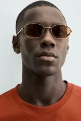 Camiseta de manga corta y cuello redondo, color terracota, con un pequeño bordado de una flor amarilla y la inscripción "Abstract Harmony" en el pecho.