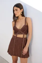 Minifalda tejida color marrón con lurex dorado, corte acampanado y pretina elástica.