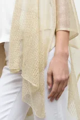 Ruana de tejido abierto con hilo de lurex dorado, diseño amplio y caída ligera.
