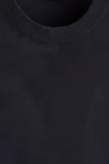 Buzo negro de punto fino con cuello redondo y remates acanalados en cuello, puños y bajo. Presenta un corte estándar para una silueta clásica y cómoda.