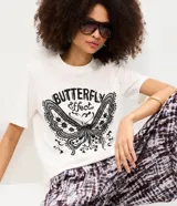 Remera de algodón color blanco, de corte holgado y manga corta, con cuello redondo y estampa frontal en negro con la inscripción "Butterfly Effect" y un diseño de mariposa.