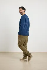 Remera de manga larga en tejido elastizado, color azul, con cuello tipo camisa, cartera con botones y detalles en eco gamuza en la base del cuello y la cartera.