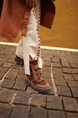 Borcegos de gamuza y terciopelo color marrón, con cordones y suela de goma negra.