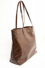 Bolso tipo shopper color marrón de cuero sintético con diseño trenzado. Cuenta con doble asa de hombro y placa metálica con el logo de la marca en el frente.