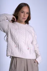 Sweater color crema de punto con diseño de ochos y flores bordadas. De corte holgado y mangas largas.