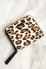 Billetera con cierre de cremallera y estampado animal print de leopardo.