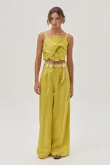 Pantalón sastrero de tiro alto color verde lima, confeccionado en tafeta metalizada, con calce holgado y pierna ancha.