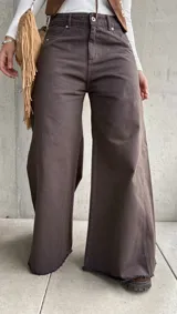 Jean de corte wide leg en color chocolate, confeccionado en denim con costuras verticales decorativas y ruedo deshilachado.